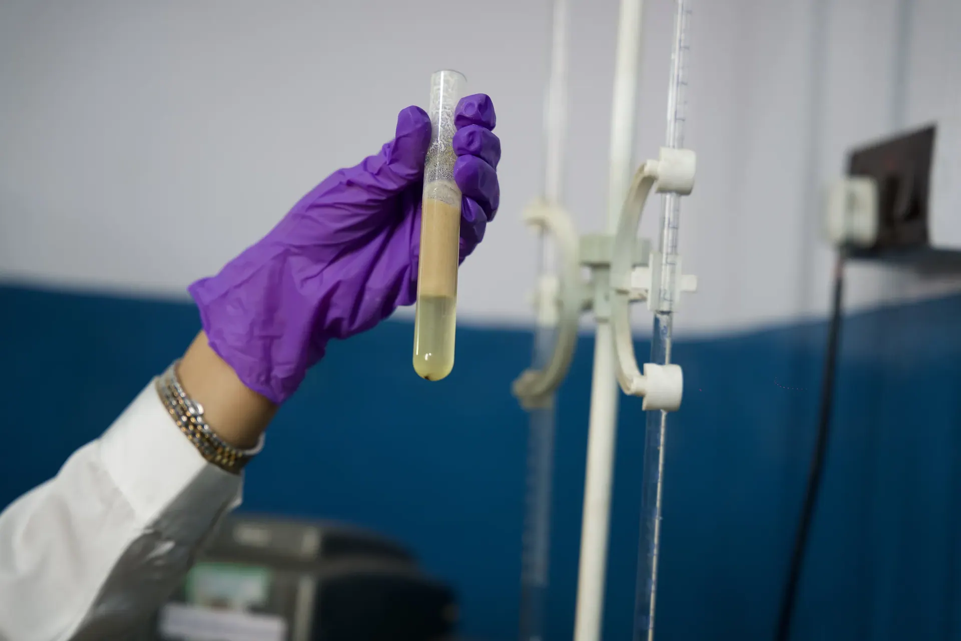A lab technician holding up a test tube during a purity test